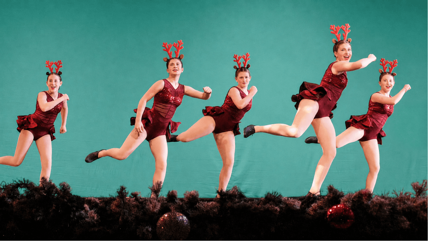 Momentum dancers performing on stage in red costumes